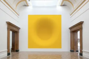 "Yellow" (1999) is a part of Anish Kapoor's series featured at the 4th Berlin Biennale. This vibrant piece engages viewers with its bold, yellow pigment and its dynamic, three-dimensional form. Kapoor's exploration of color and shape captivates the eye, creating a striking visual experience that challenges conventional artistic norms.Yellow
